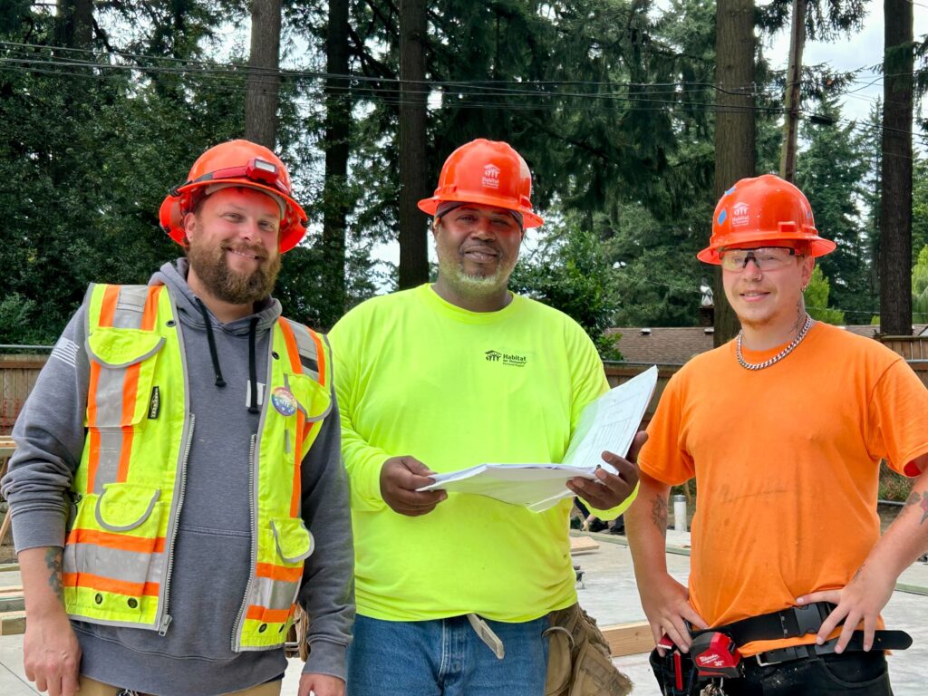 Habitat staff hold plans for framing an affordable home