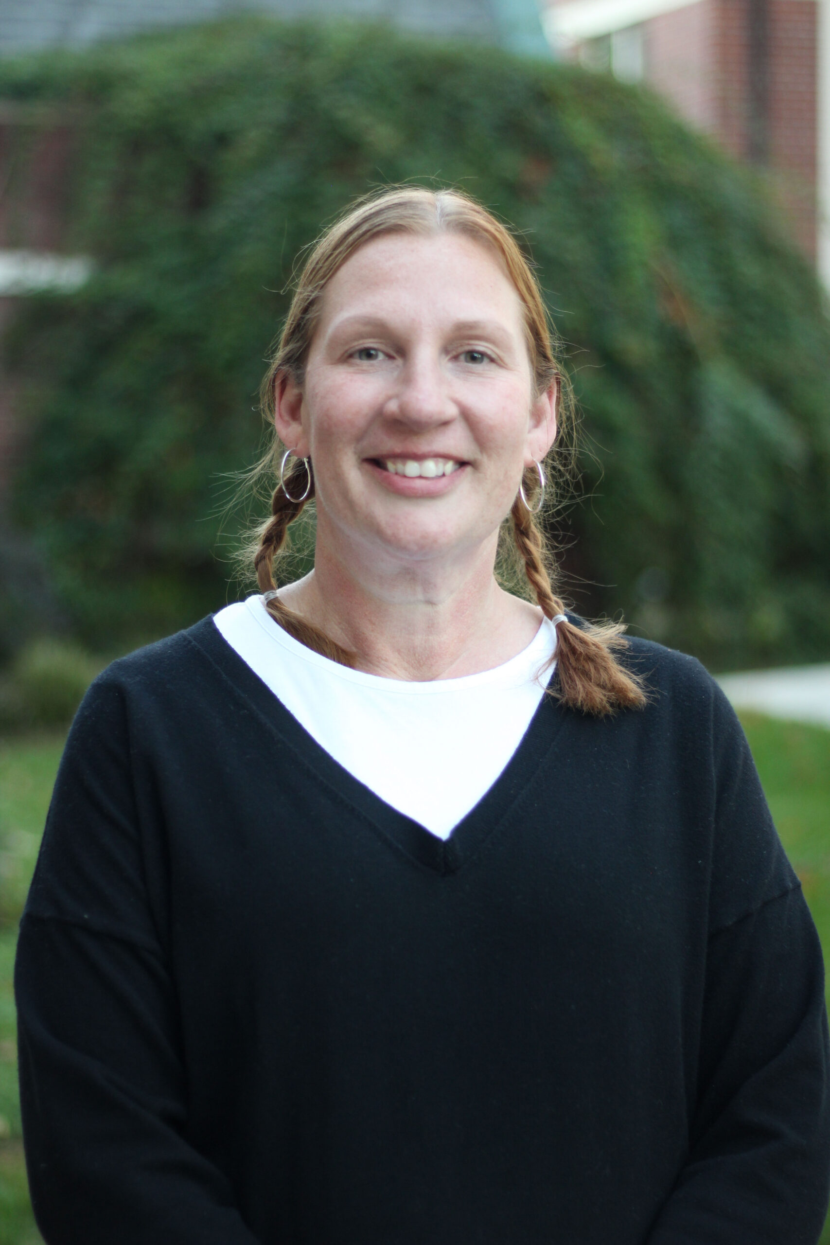 Habitat homebuyer Teri smiles in front of her current apartment building's courtyard.