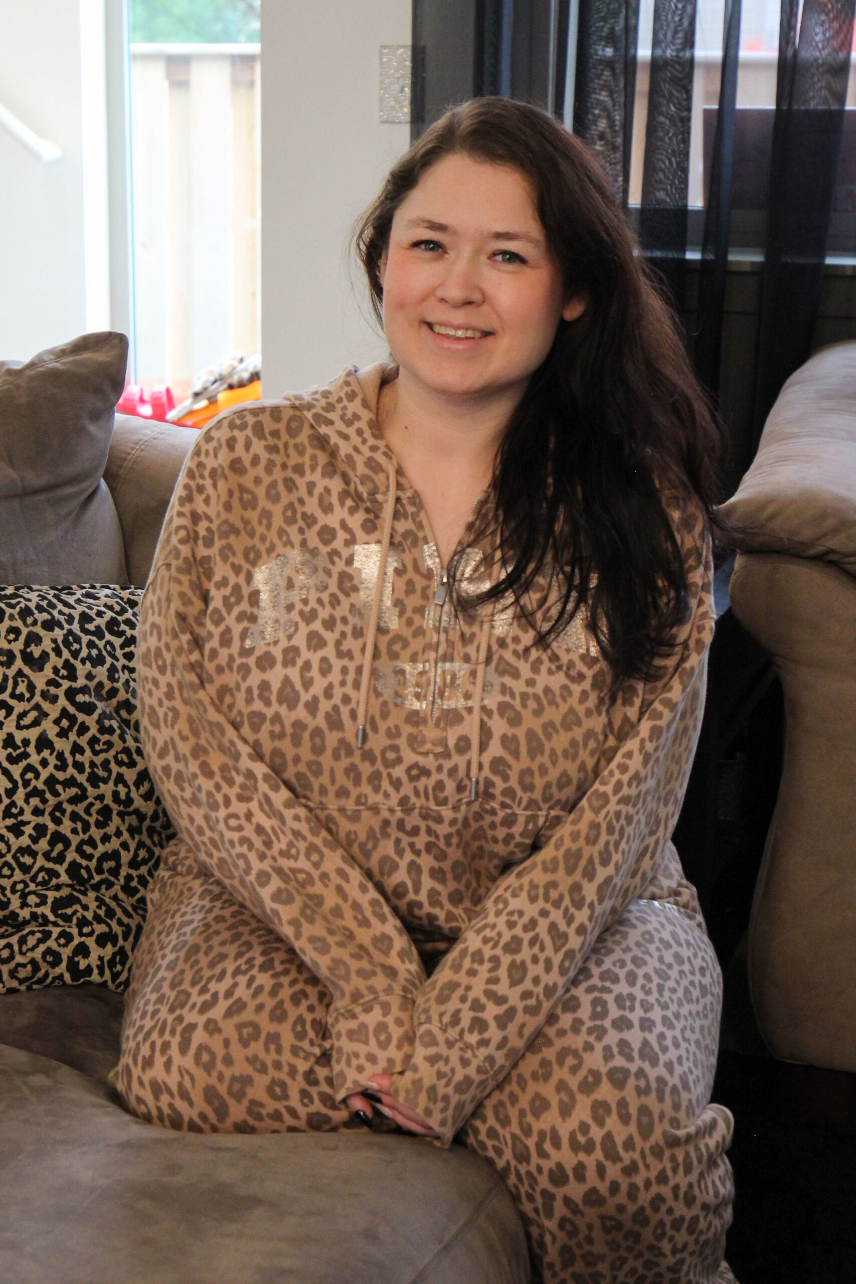 Rachael, a Habitat homeowner, smiles, sitting in her living room.