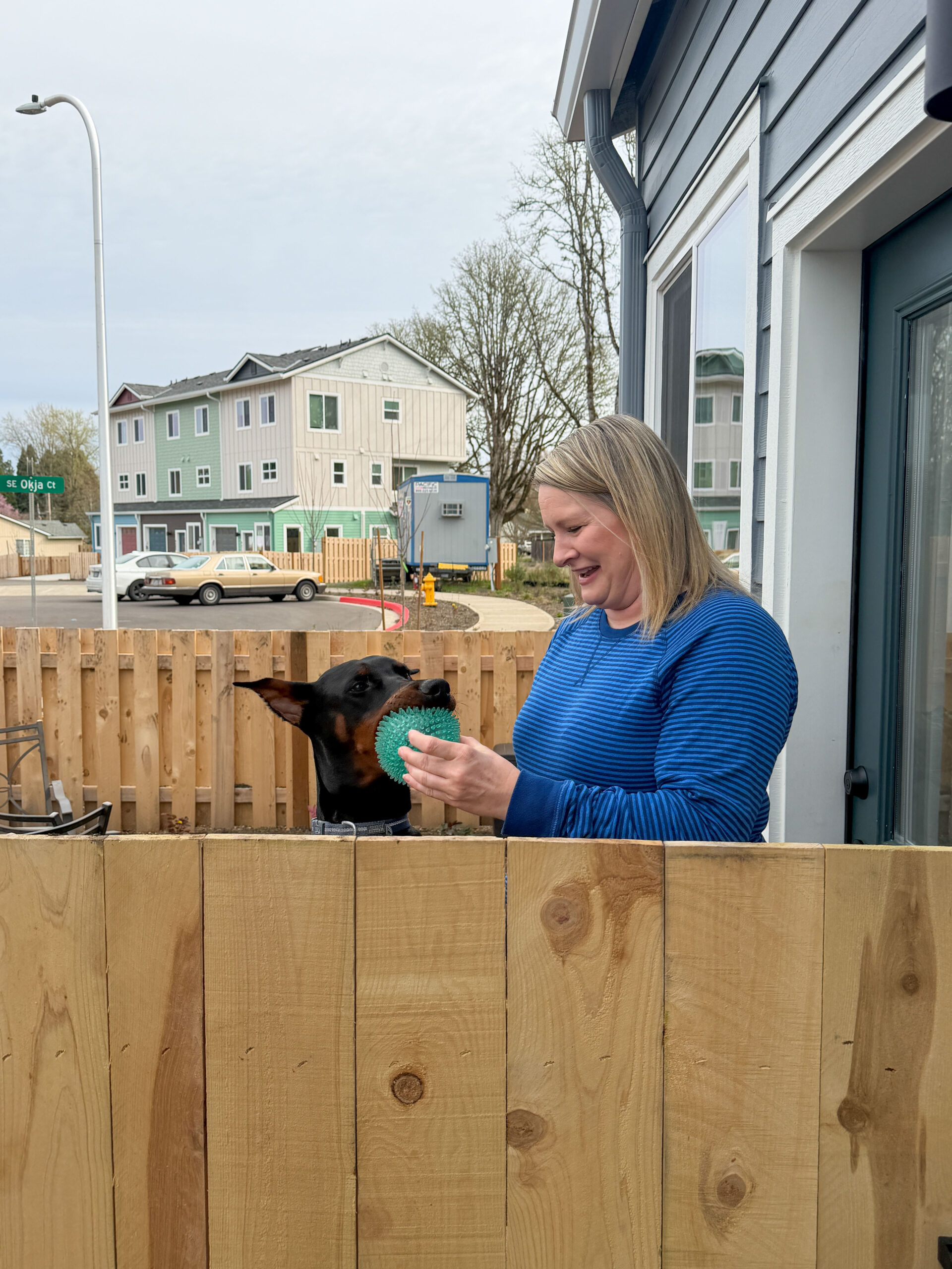 Duffy smiles, playing with her dog Rocket in their front yard.