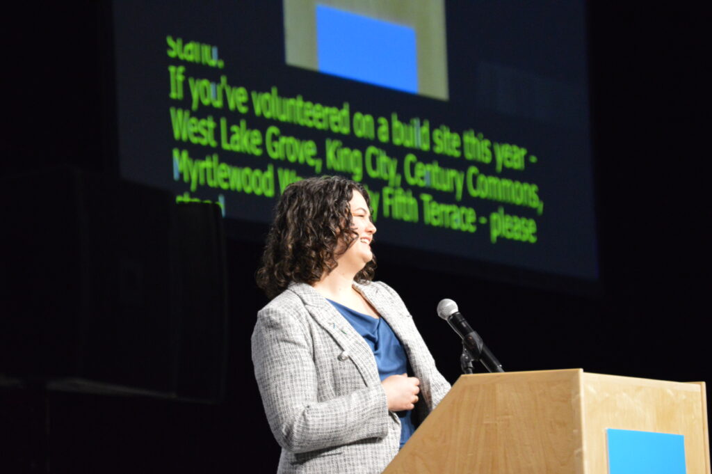 Claire beams on stage at HopeBuilder 2026.